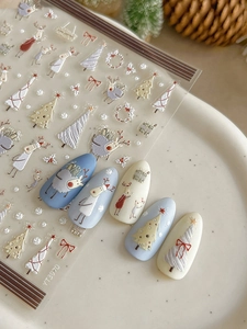 Macro detail of 3D embossed Christmas nail stickers with reindeer and tree patterns