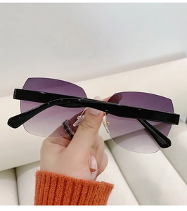 Close-up of rimless sunglasses with purple gradient lenses and black temples