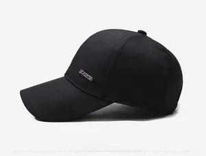 Close-up of a black baseball cap featuring a silver SPORTS metal badge on the side