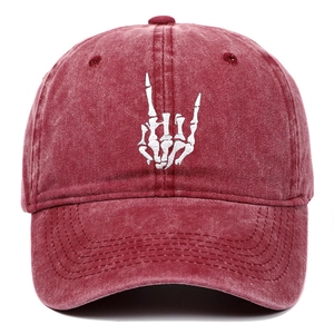 Detail of white bone rock hand gesture embroidery on washed red cotton baseball cap