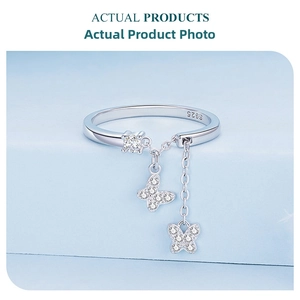 Detail of S925 silver butterfly ring with dangling tassels and Zircon stone on a blue stand