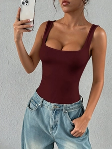 Close-up of slim-fit dark red square-neck tube top paired with blue jeans in a mirror selfie