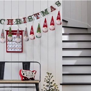 Christmas gnome ornaments and festive calendar pocket hanging on a white wooden wall