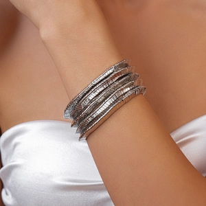 Detailed close-up of a silver multi-layered Tubogas style spiral bracelet on a wrist