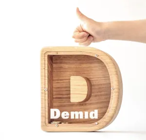 Detail of D-shaped wooden letter piggy bank with transparent window and coins inside
