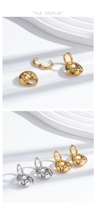 Detail view of gold and silver croissant earrings with thick textured pendants on white
