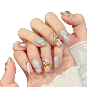 Handmade gold-lined press-on nails with marble texture, glitter finish, and pearl accents