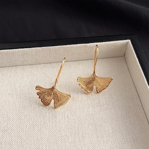 Macro shot of 14K gold plated ginkgo leaf earrings with fine texture in a jewelry box