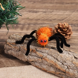 Detail shot of a plush orange Halloween spider with red eyes on a natural wooden log