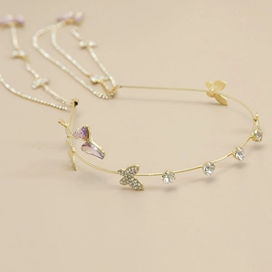 Detailed close-up of golden butterfly headband with purple crystals and hanging tassels