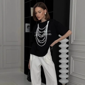 Detail of black cotton T-shirt featuring realistic pearl necklace print and typography