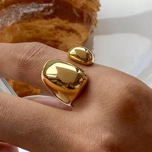 Nahaufnahme eines goldenen unregelmäßigen Kieselrings, getragen in einer Lifestyle-Szene