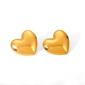 Macro view of highly polished 3D heart-shaped earrings in shiny 18K gold finish