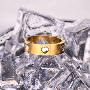Macro shot of 18K gold plated ring with heart-shaped zircons on ice with water drops