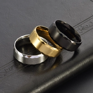 Detail view of 8mm wide brushed titanium steel rings in silver, gold, and black finishes