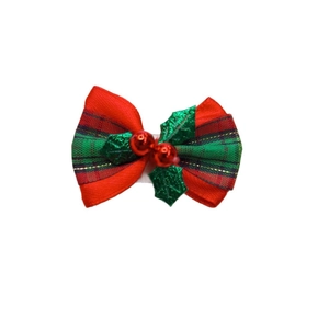 Detailed view of red and green Christmas bow with holly leaves for festive DIY gift decor