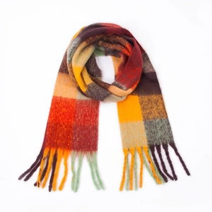 Flat lay detail of warm multi-color checkered scarf with braided cashmere-like fringes