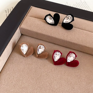 Macro view of velvet heart earrings with pear-cut zircon in black, brown and burgundy