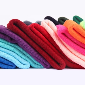 Multiple colors of warm winter knit beanies with premium texture stacked on white background