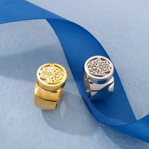 Detail of gold and silver spinning rings with hollow Hamsa Hand design on blue ribbon
