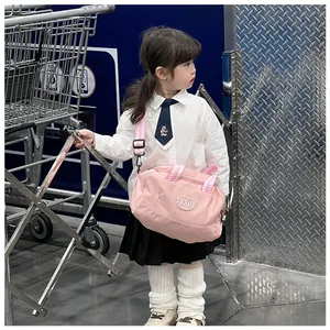 Close-up of pink children's dance bag with TOCHASO text and checkered straps