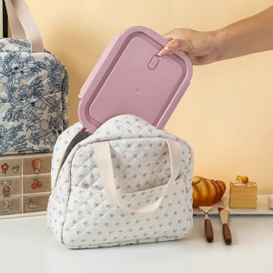 Bolsa térmica acolchada con flores mostrando cómo se guarda un porta almuerzo lila