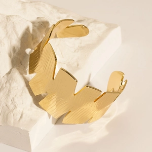Macro shot of gold-plated leaf texture on stainless steel C-shape bangle bracelet