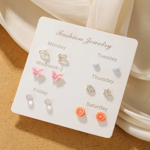 Close-up of 6 pairs of butterfly, heart and star stud earrings on a fashion display card