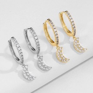 Close-up of gold and silver moon earrings with micro-pave cubic zirconia inlay