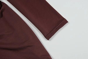Macro shot of dark wine red knit dress sleeve showing detailed stitching and elastic fabric