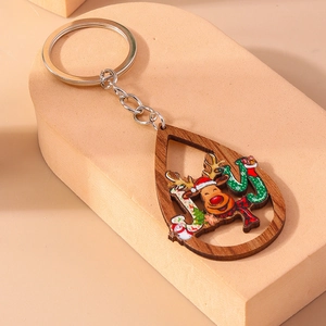 Détail d'un porte-clés de Noël en bois avec lettrage JOY et motif de renne festif
