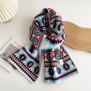 Detail view of ethnic geometric jacquard knit scarf with thick wool texture and logo