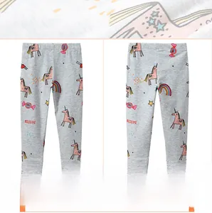 Detail view of girls gray leggings with cartoon unicorn and rainbow prints for autumn