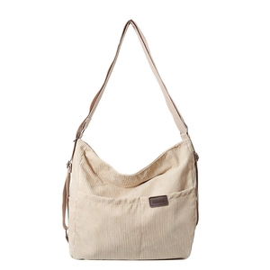 Sac bandoulière en velours côtelé beige avec sangle réglable et poche avant sur fond blanc