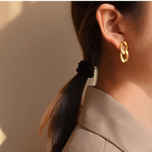 Close-up of a 18K gold plated irregular geometric figure-8 chain earring on a model