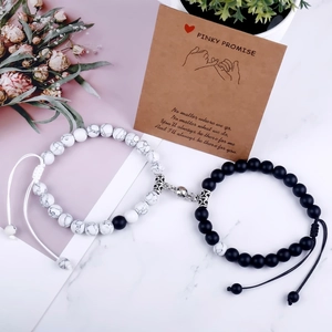 Detail of beaded magnetic couple bracelets with heart clasp on marble surface