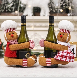 Detail of plush gingerbread man wine bottle covers with festive Christmas fireplace decor