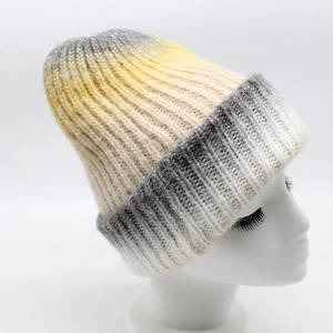 Detail of yellow and grey tie-dye gradient knit beanie with soft thick texture