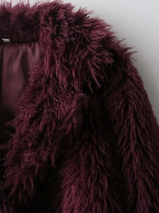 Close-up of wine red faux fur coat showing plush texture and silk-like inner lining