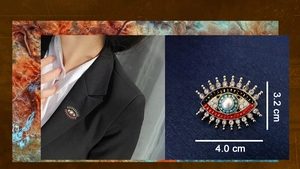 Detailed size view of an evil eye brooch with pearls and rhinestones on a blazer