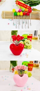 Macro detail of colorful heart and star shaped stainless steel fruit forks in holder