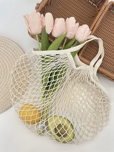 Minimalist cream woven mesh tote bag with flowers and fruits in a rustic French style