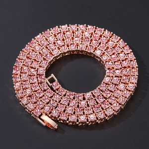 Detail view of pink rhinestone tennis chain necklace with rose gold plating on black background