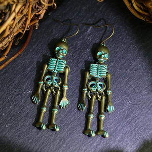 Macro shot of vintage bronze skull earrings with movable joints and aged metal texture