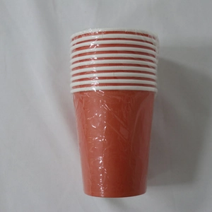 Close-up of orange disposable paper cups stacked in clear plastic wrap for party supplies