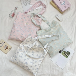 Flat lay of pink, green and white canvas tote bags with cute cartoon cat pattern prints