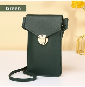 Detail of dark green crossbody phone bag with gold metal lock and pebble leather texture