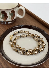Vue détaillée du collier plaqué or avec pierres œil de tigre brunes et perles champagne