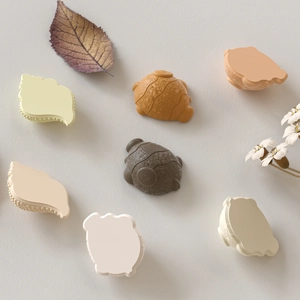 Macro view of shell and turtle resin charms in muted Morandi tones for DIY crafts