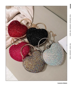 Top view of five heart-shaped evening bags with rhinestones in red, black, gold and silver